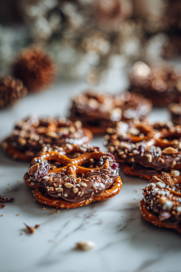 Čokoládové preclíky polité rozpuštěnou čokoládou a posypané ořechy, ideální na podzimní večírky.