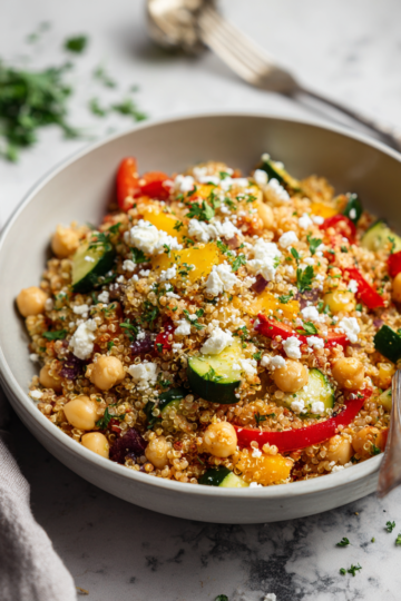 Lahodný quinoa salát s čerstvou zeleninou a feta sýrem na podzimním stole.
